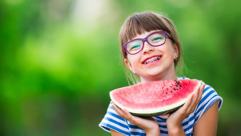 smiling child with her braces from arcade dental not nervous about braces